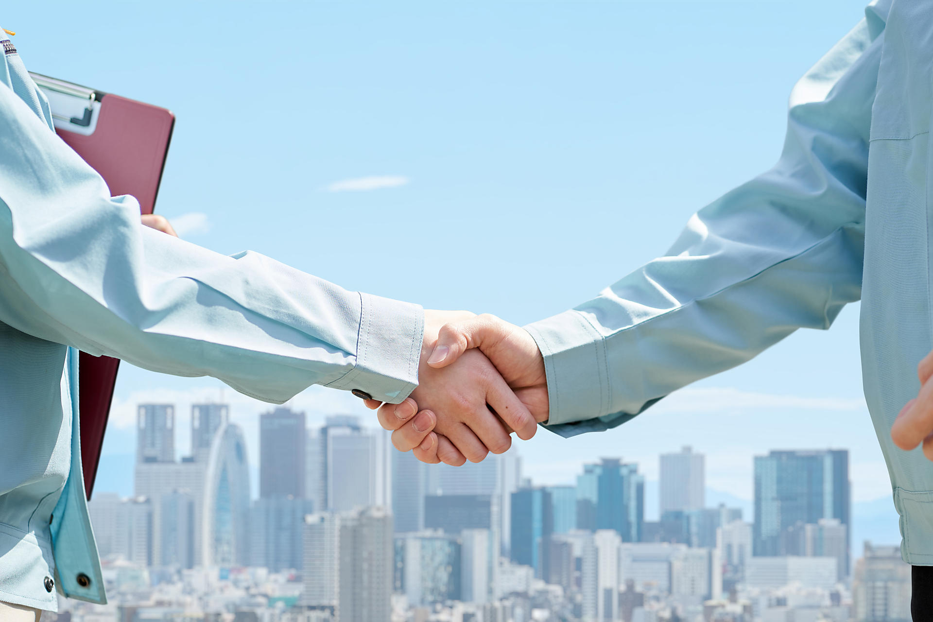 作業服の人が握手している画像